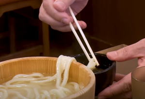 桶の縁をはわせる麺